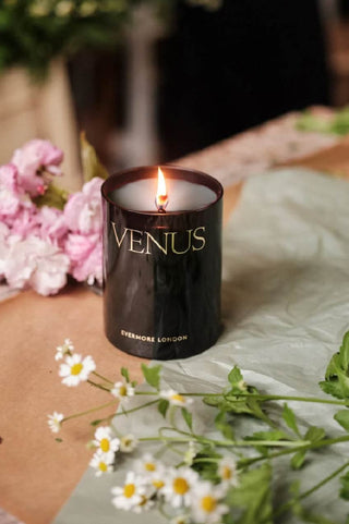 Evermore London Venus Candle 300g on table with cut pink carnation and daisy flowers