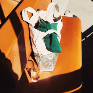 P.F. Candle Co Bergamot Shiso Mood neutral color tote bag set on retro orange bus seat bathed in sunlight